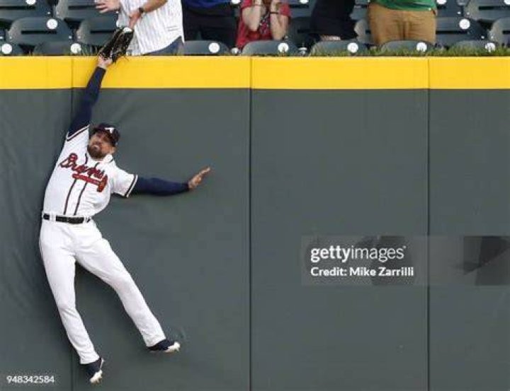 Can an outfielder climb the wall to make a catch?